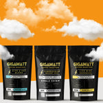 Gigawatt Coffee Dark Roast Coffee Sampler with bestselling Live Wire Espresso Blend, Kite & Key Blend, and Cameroonian Mount Oku. A mix of dark roasts with smooth, balanced flavor. 10 oz bags, set against a cloud-filled background.