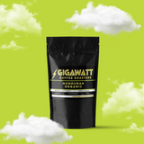 Gigawatt Coffee Organic Honduran Coffee, medium light roast blueberry coffee with smooth and vibrant flavors. 3 oz coffee sampler pack, set against a cloud-filled background.